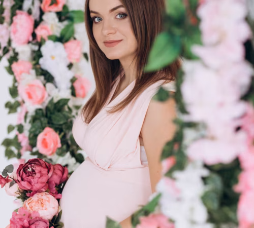 sensitive-portrait-pregnant-woman-expecting-lady-pink-dress-poses-with-flowers_8353-8286