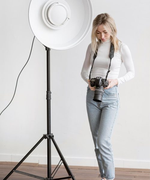 studio-lamp-woman-holding-camera-photo_23-2148565484